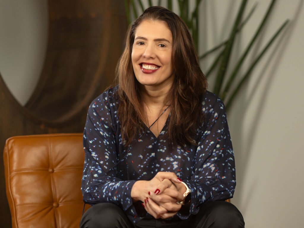 Heloíza Carvalho, CEO da Tree Comunicação, Sentada no Sofá e Sorrindo